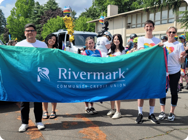Rivermark employees holding up a Rivermark banner.